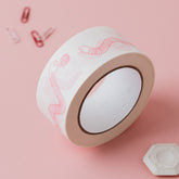 Feed the worms paper tape on pale pink background