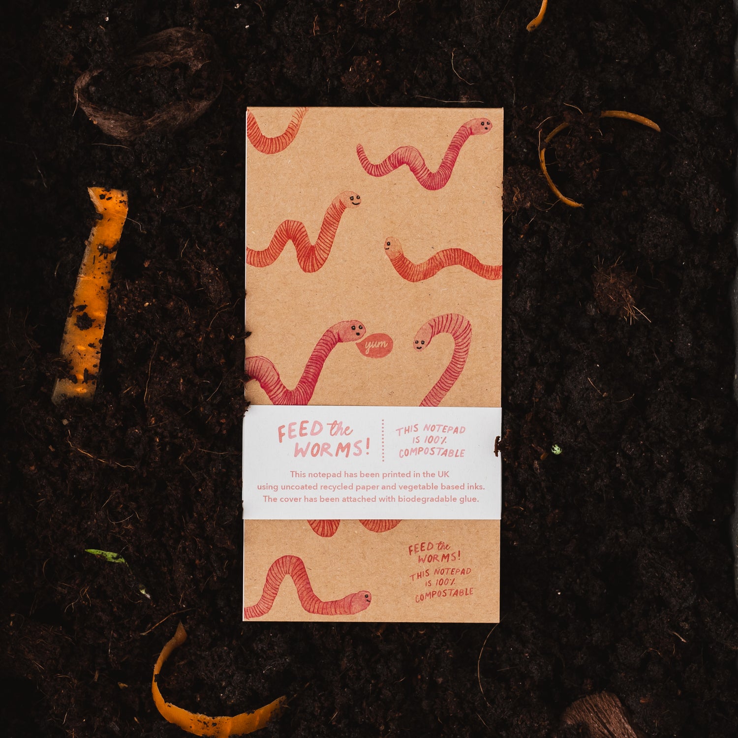 Feed the Worms 100% Compostable Notepad on a bed of compost